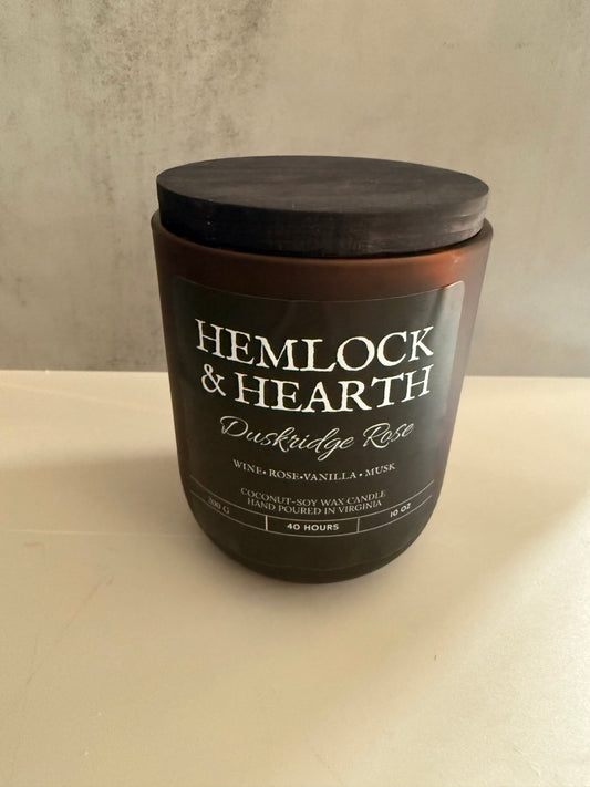 Candle with 'Hemlock & Hearth' branding on a neutral background